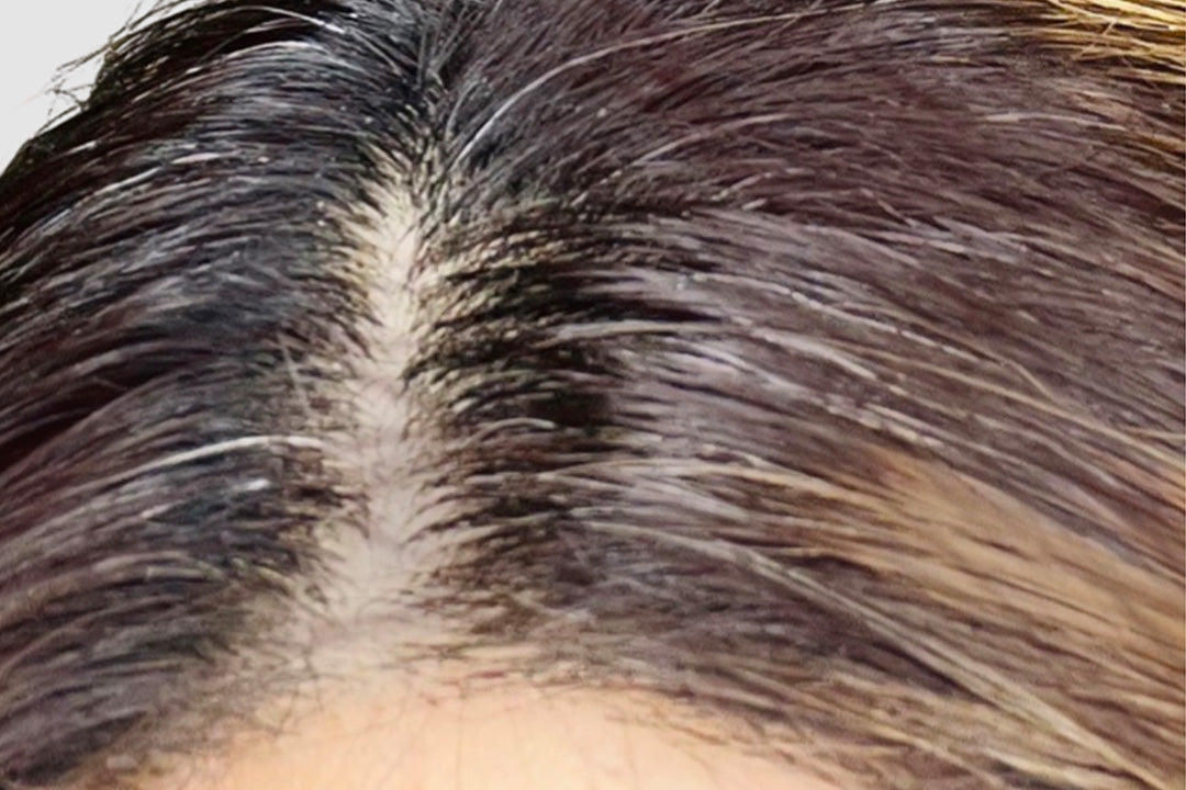 Close-up of dark hair roots with visible gray strands. Hair looks healthy and shiny, highlighting the potential benefits of collagen supplements.