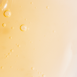 Close-up of bubbly amber liquid, likely collagen serum, with light reflections. Ideal for beauty and supplements context.