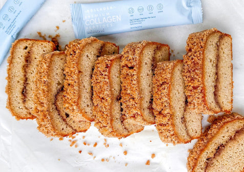 Sliced crumb cake on parchment paper with collagen supplement packs in the background.
