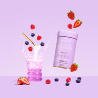 Collagen supplement with mixed berries, pink drink splashing from a glass with a straw on a pastel lavender background.