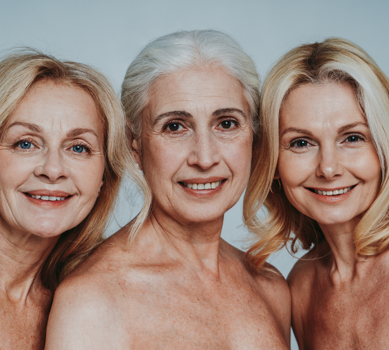 Three smiling older women with natural, radiant skin stand closely, embodying beauty and wellness. Ideal for promoting collagen supplements.