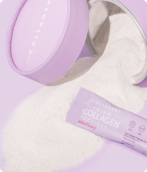 Purple container and sachet of mixed berry collagen peptides spill powder onto a purple surface, highlighting beauty supplement features.