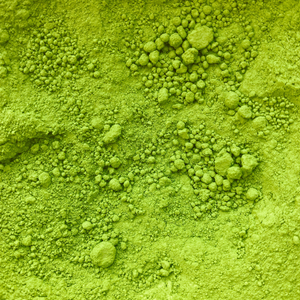 Close-up of vibrant green matcha powder, showing fine and coarse granules. Suitable for beauty and wellness supplements.